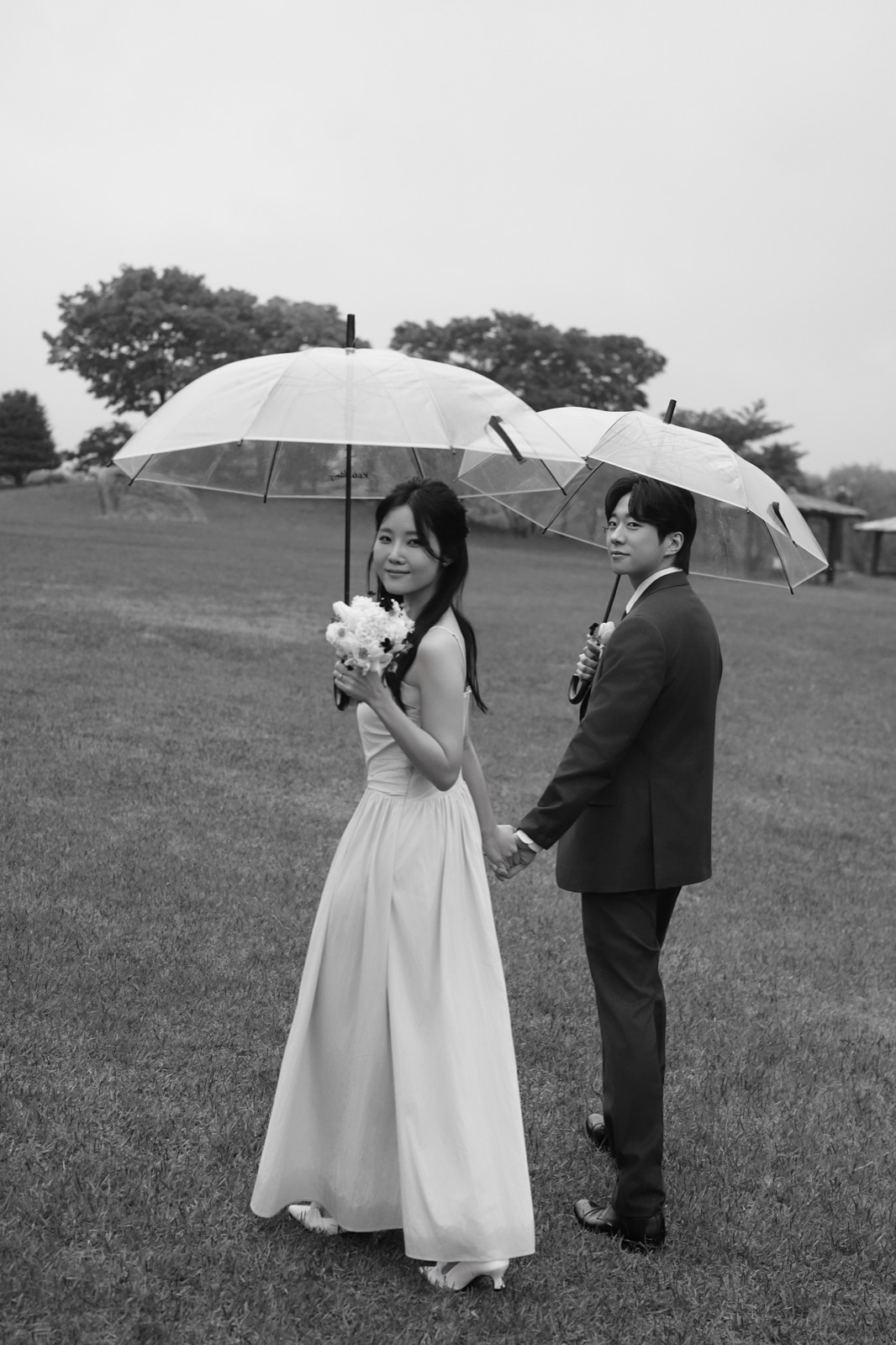 우산 아래 손을 잡고 걷는 성우와 해인의 흑백 사진
